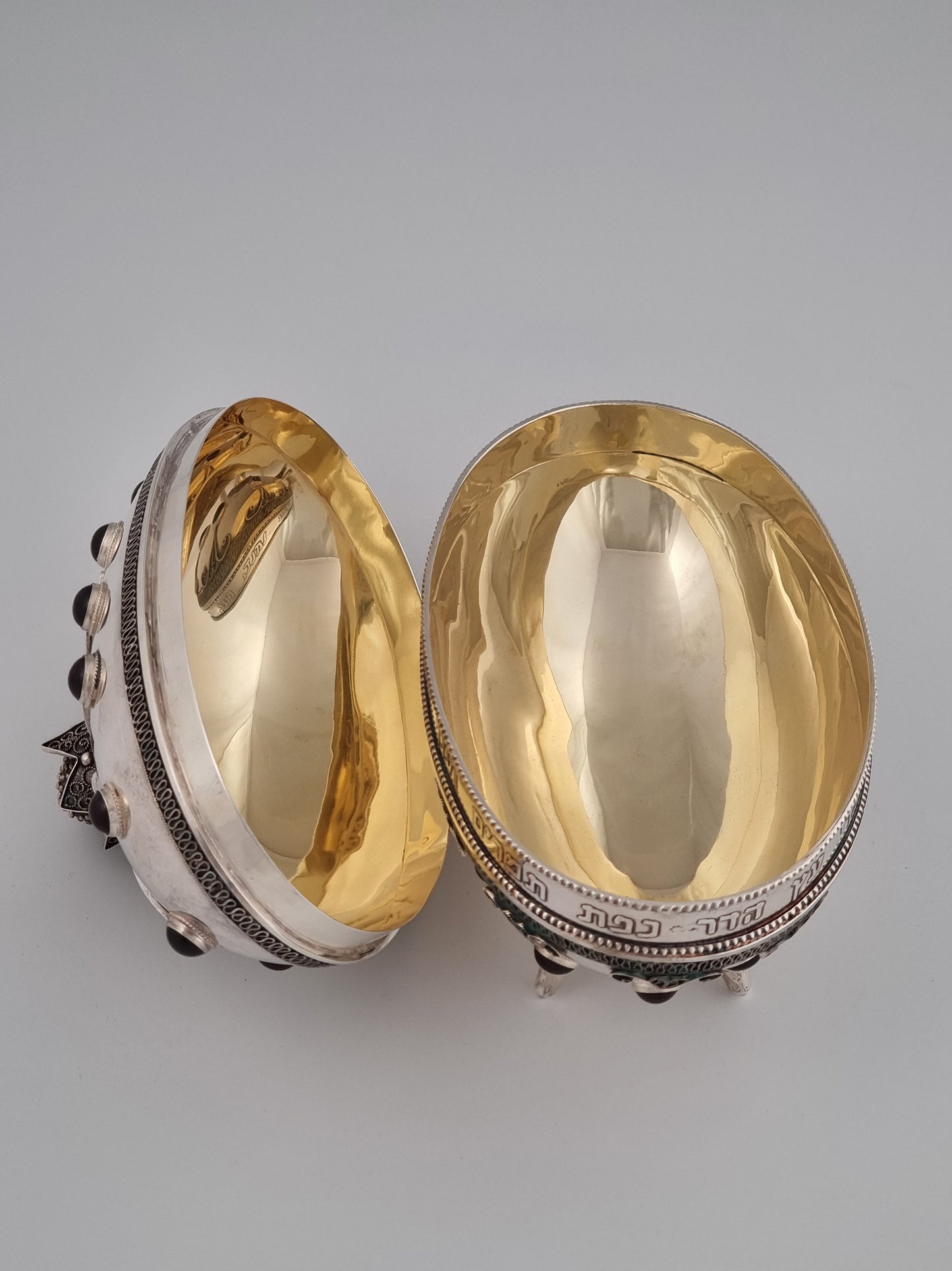 Open etrog box showing the inner smooth gold plated surface in contrast with the outer silver decorations.