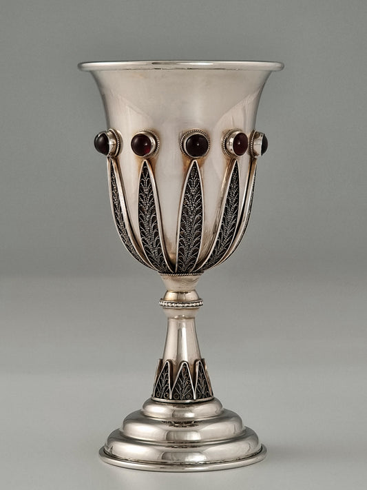 Jacob Kiddush Cup. This cup was designed in the 1960's. It is made of sterling silver, gold-plated silver on the inside, and adorned with ten garnet stones. It measures 5½" high.