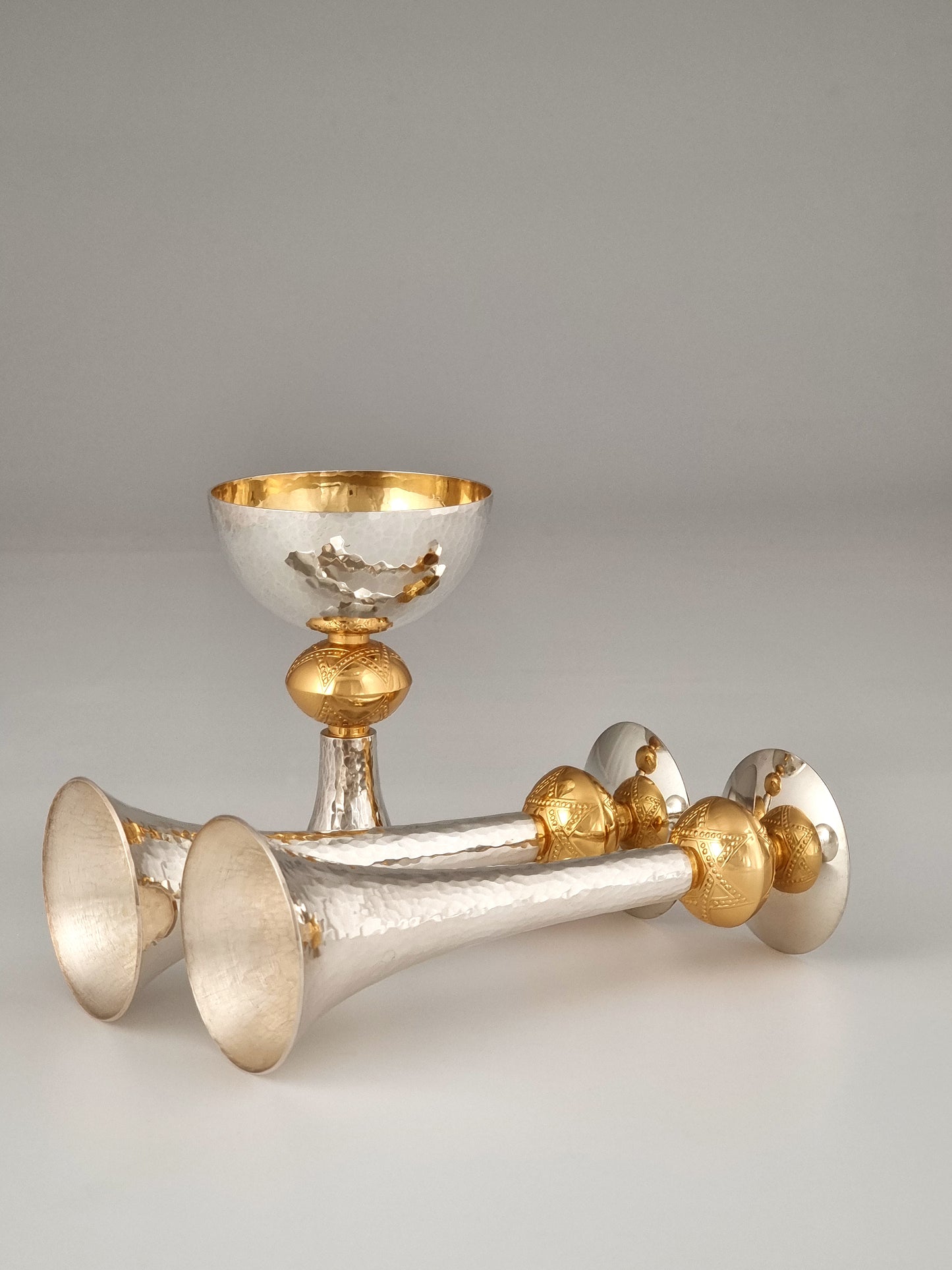 Two candlesticks reflecting in the Kiddush cup