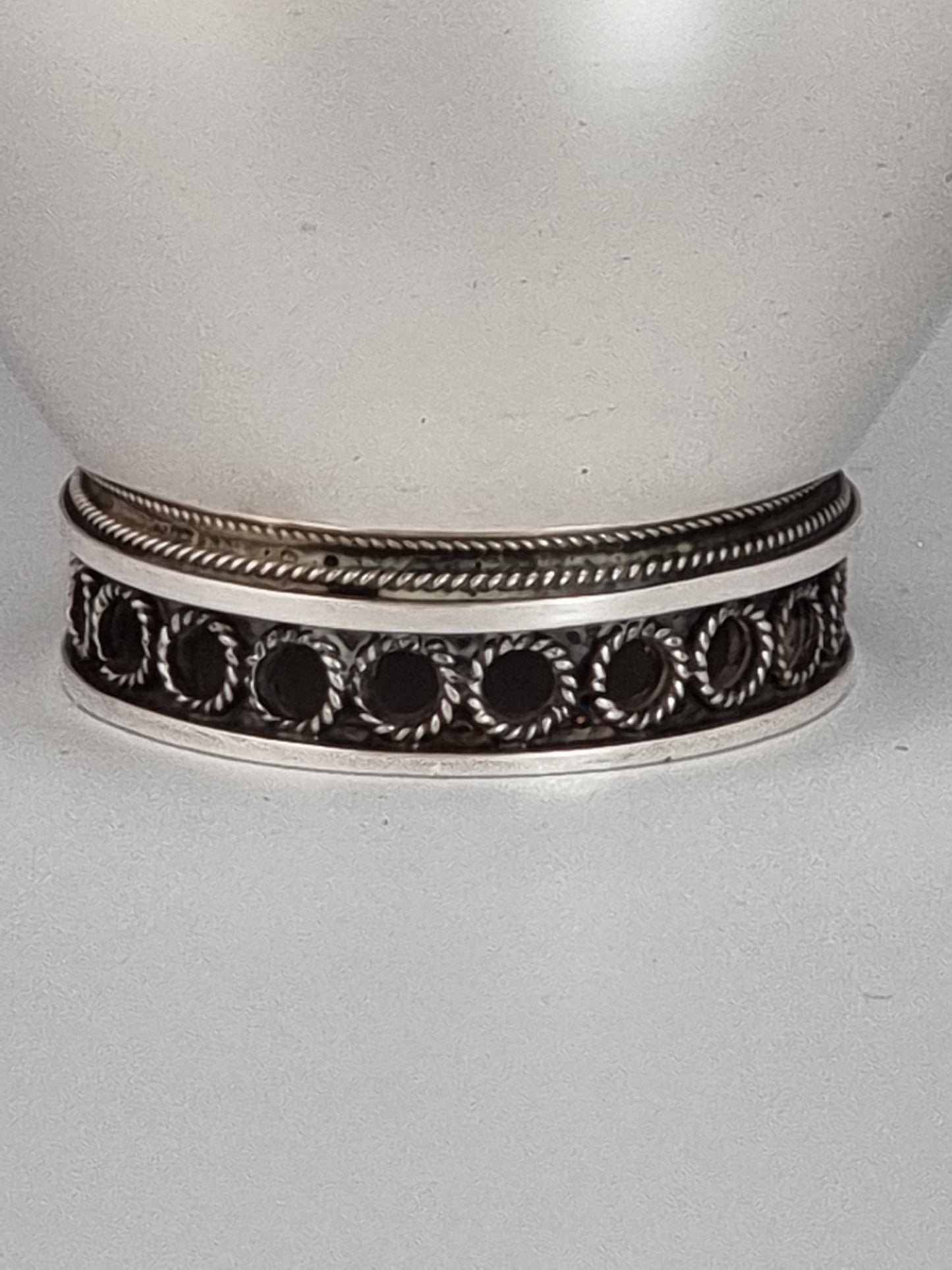 Tiny twisted rings and a double bracelet decorate the bottom of Elijah candlesticks.