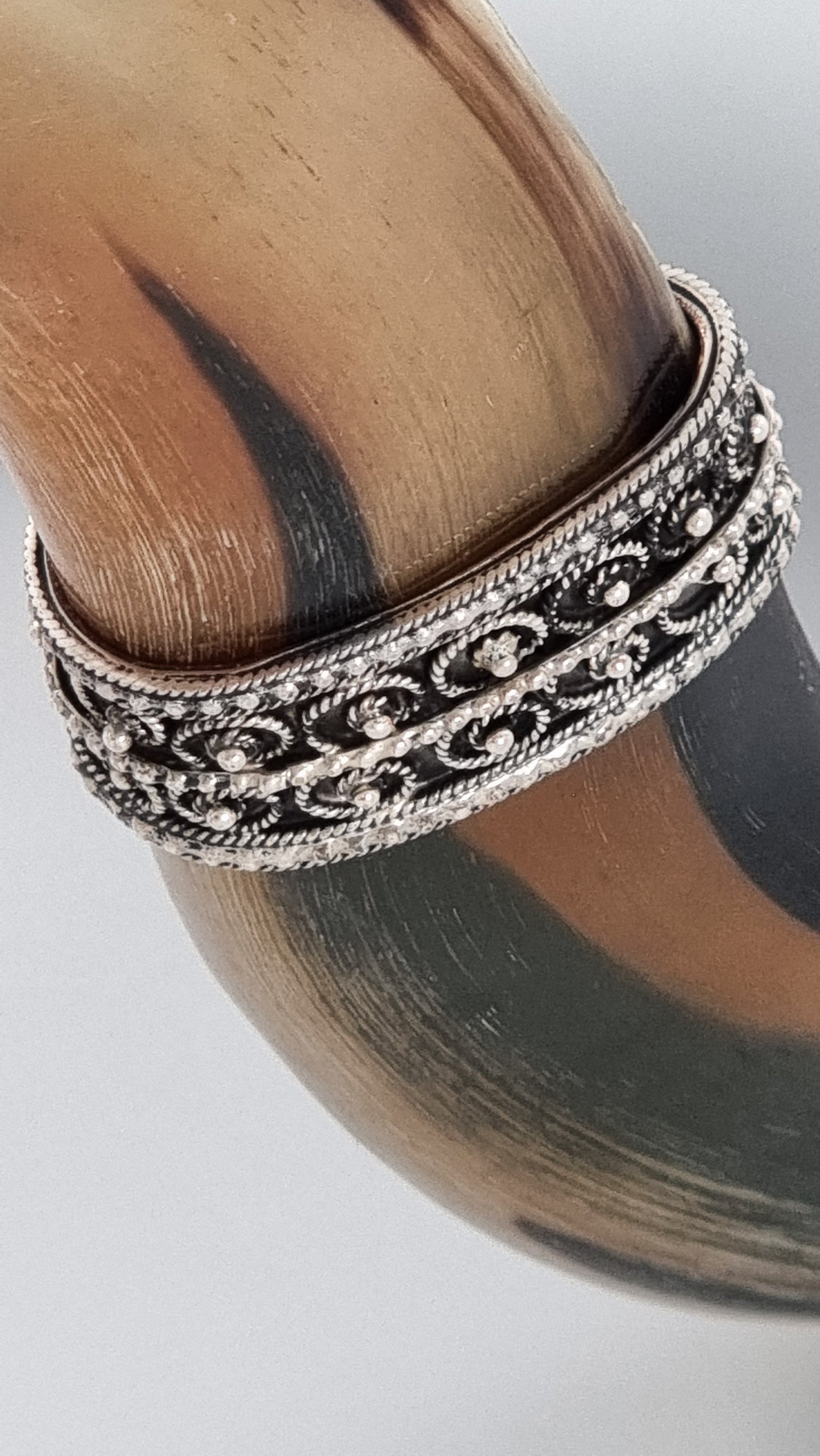 Close view of a filigree silver band on an Abraham Shofar