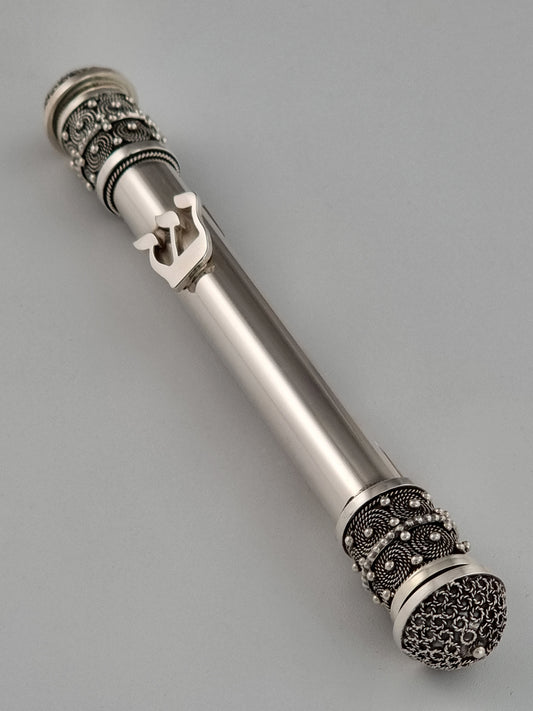 The Hebrew letter Shin decorates the front of this unique Mezuzah and breaks its cylindrical symmetry.