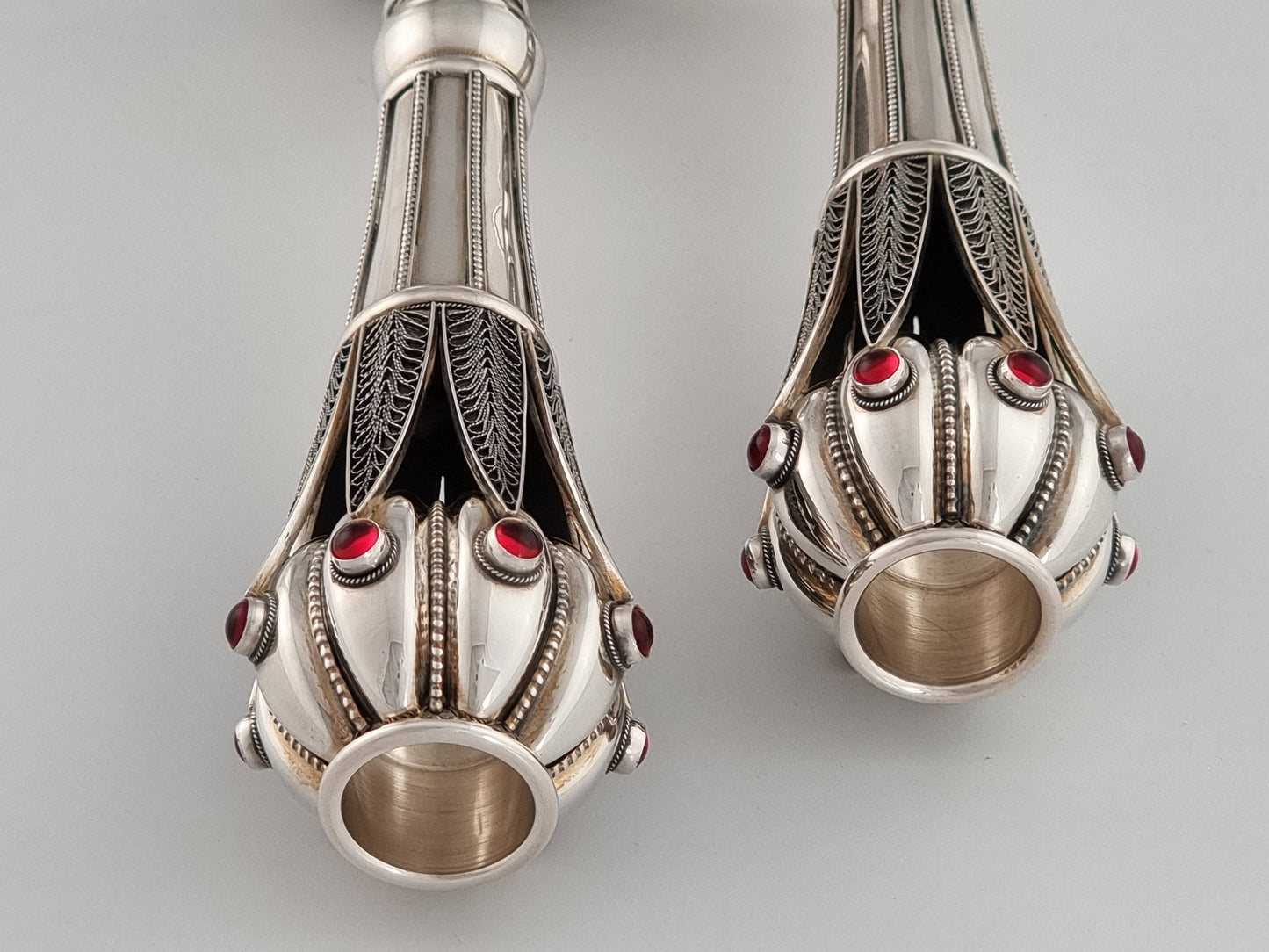 Deep dark space intrigues the eye underneath the regal candle holders at the top of this special Judaica piece.