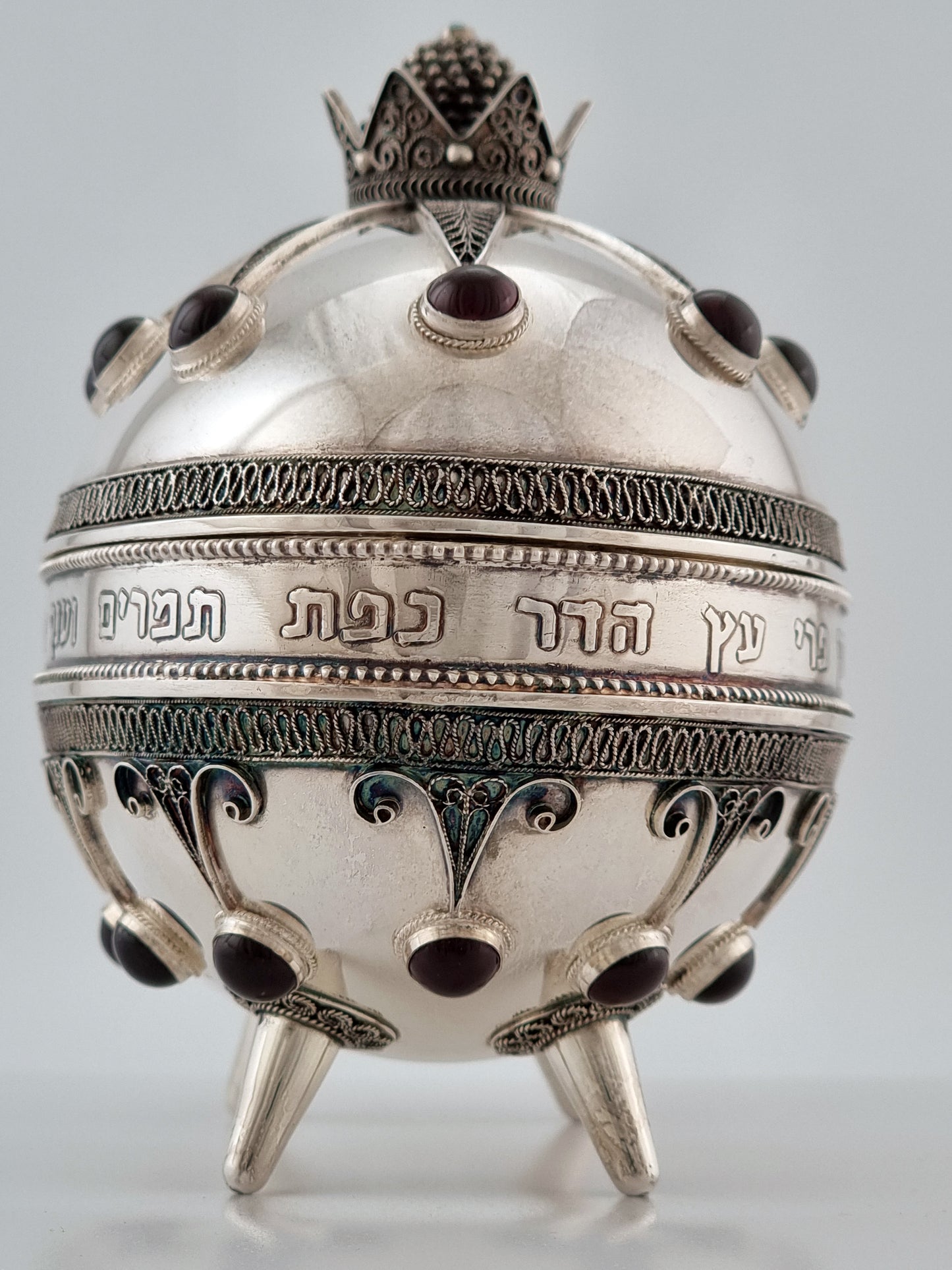 Narrow end of the oval container, showing the full body on top of short legs.