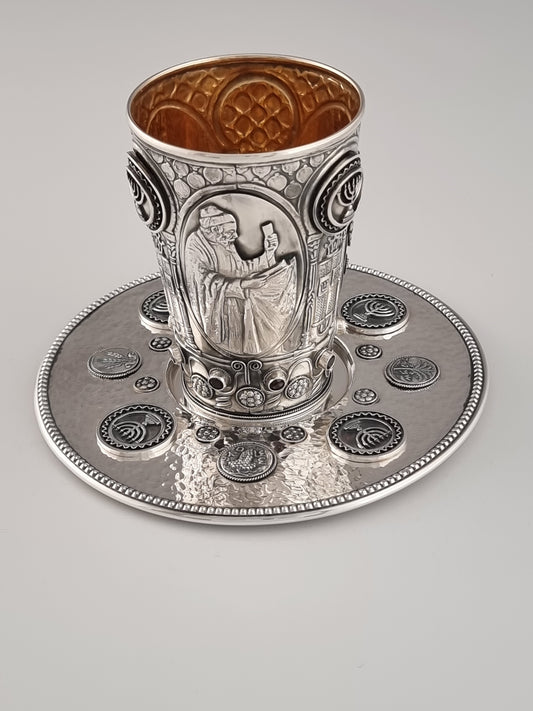 Moses Kiddush Cup and Plate. This cup and plate set was designed in the 1960's. It is made of sterling silver, gold-plated silver on the inside, and adorned with nine garnet stones. It measures 4" high.