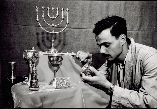 Young Yaacov Yemini, examining some of his art pieces 