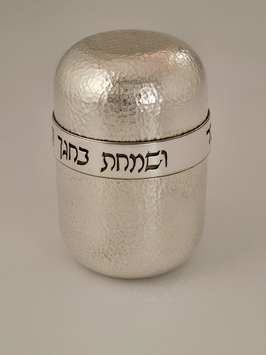 Jonah Etrog Box. This piece was designed in 2005 and is made of hammered sterling silver, and is gold-plated on the interior. It measures 5” by 3”. It is embellished in Rashi script with blessings for the Sukkot festival.