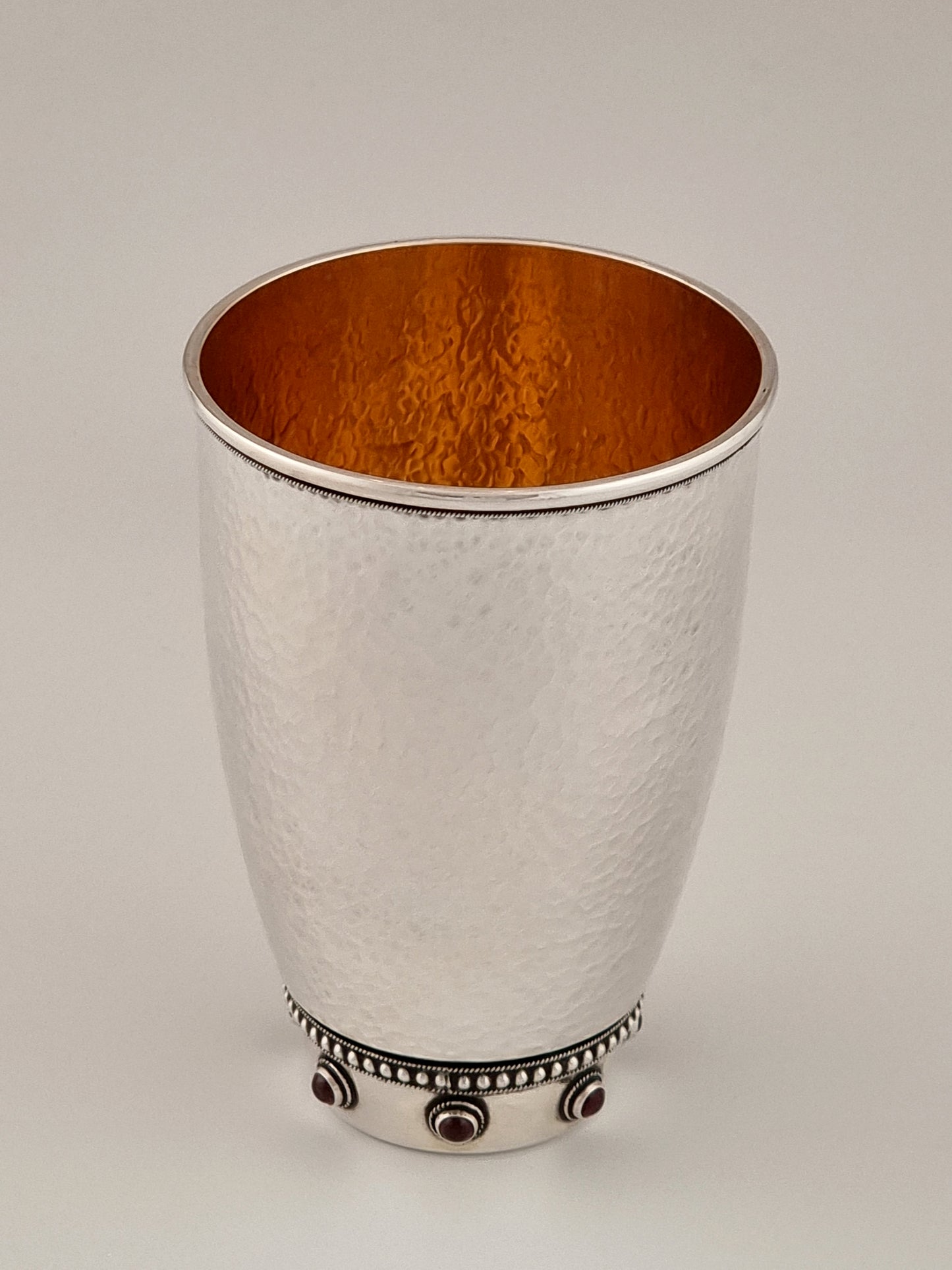 Sarah Kiddush Cup. This cup was designed in 1999. It is made of sterling silver, gold-plated silver on the inside, and adorned with seven garnet stones. It measures 4½" high.