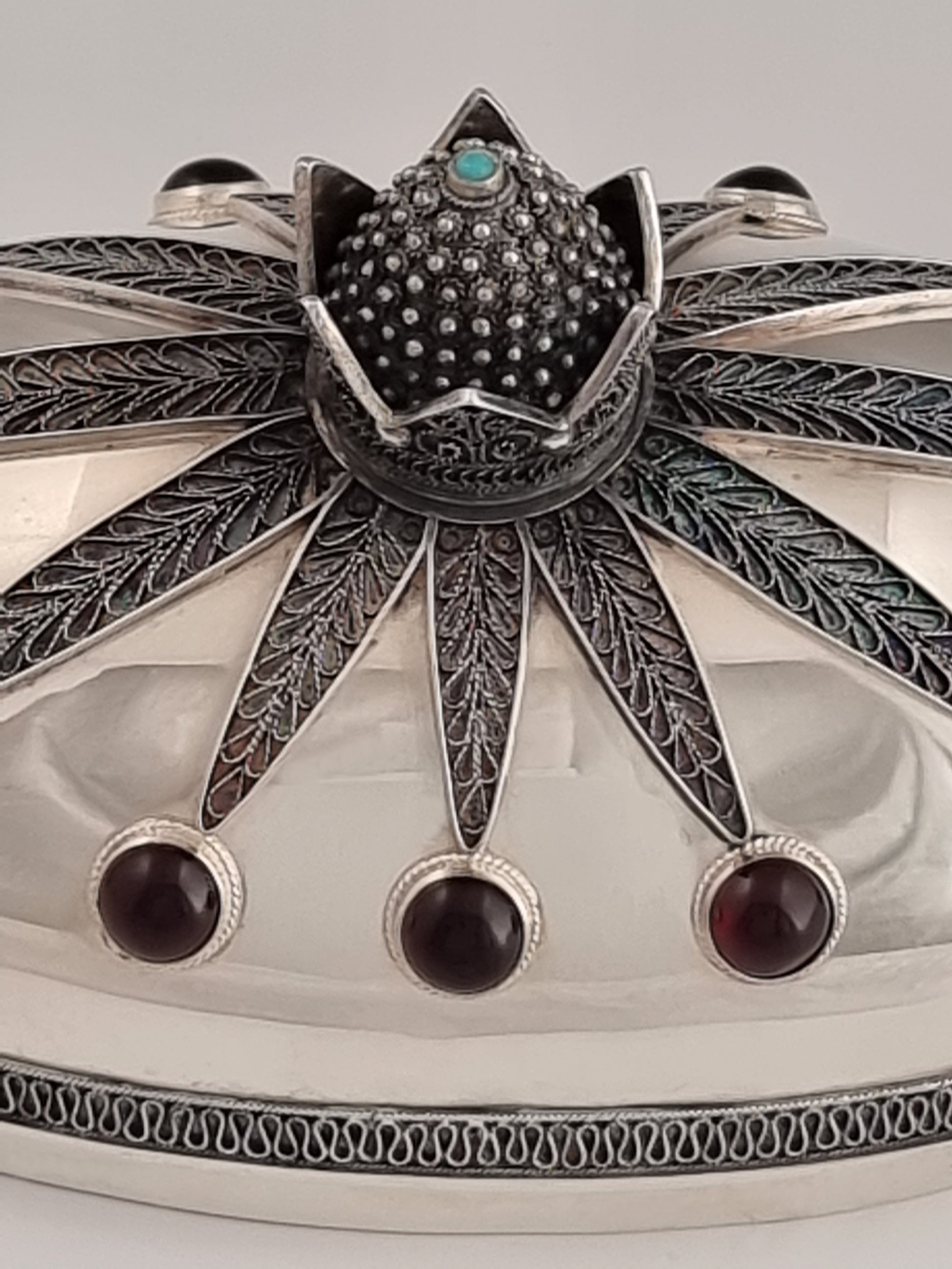 The super detailed crown of this box is topped with a single turquoise stone.