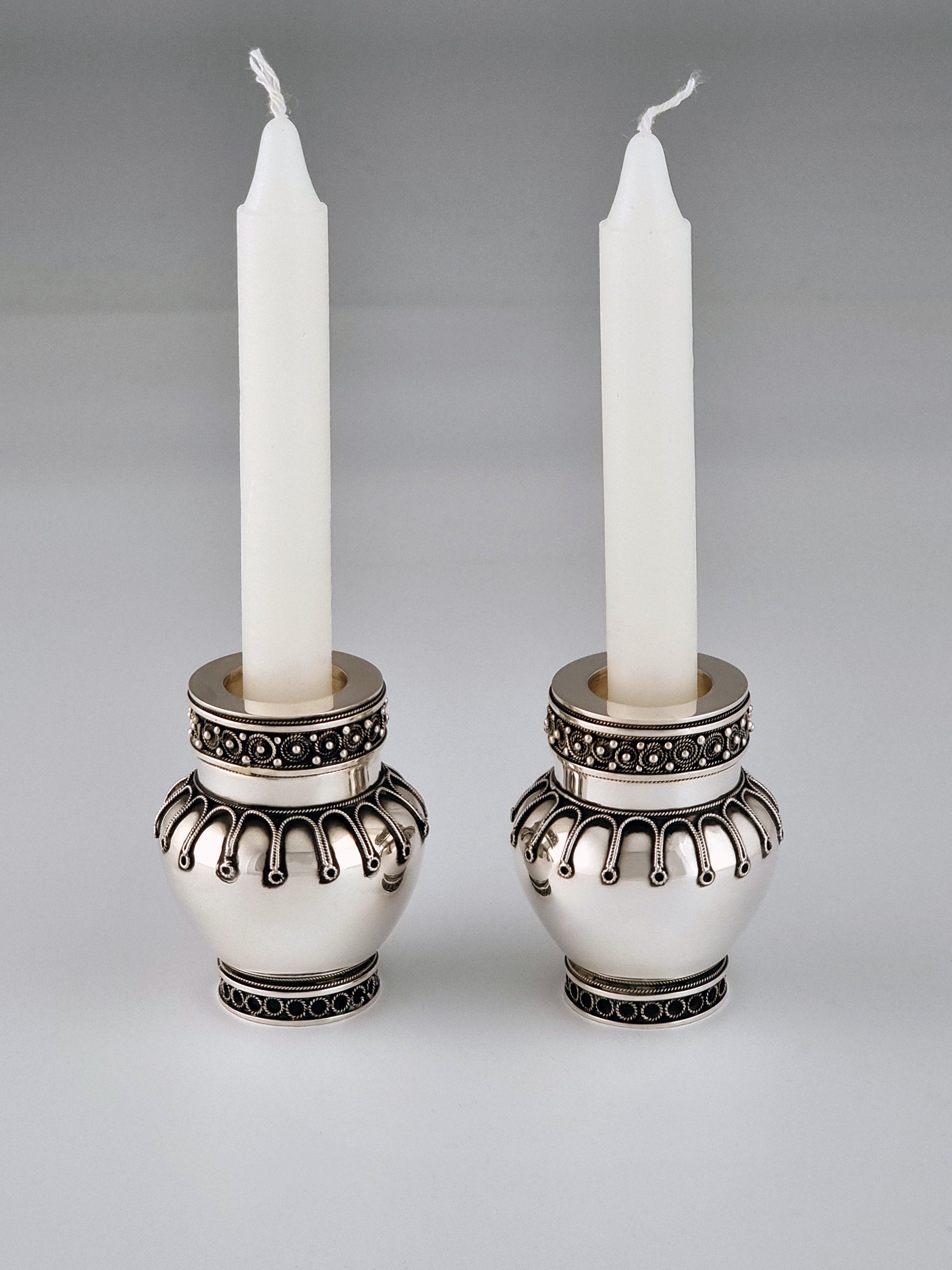 Elijah Candlesticks. These candlesticks were designed by Margie in 2003, they measure 2½” in height and are made from sterling silver.