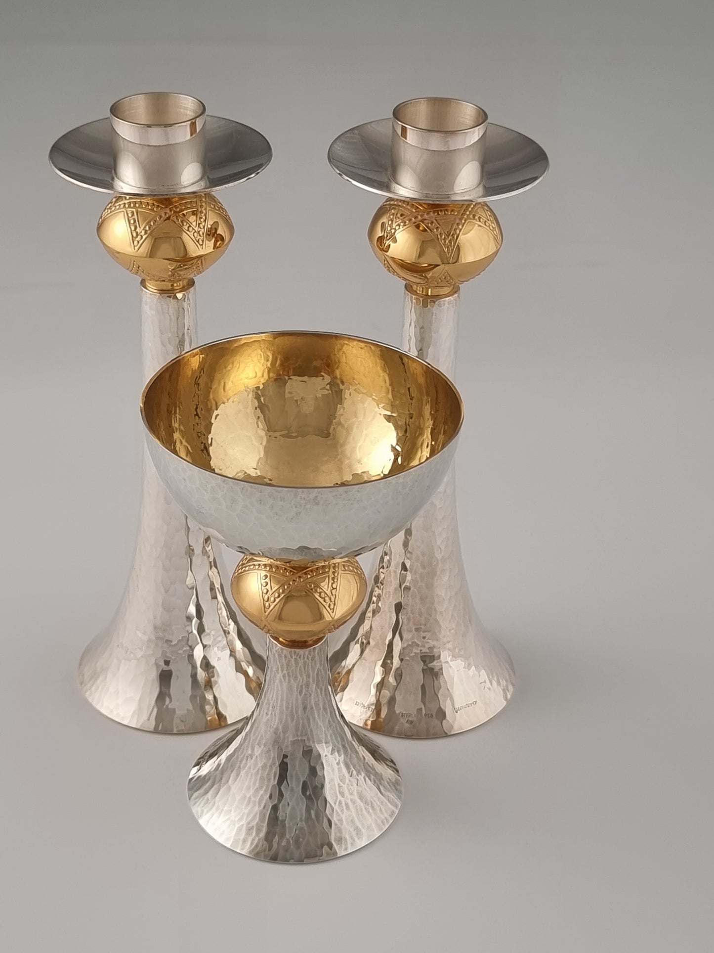 A pair of David candlesticks behind a David Kiddush cup