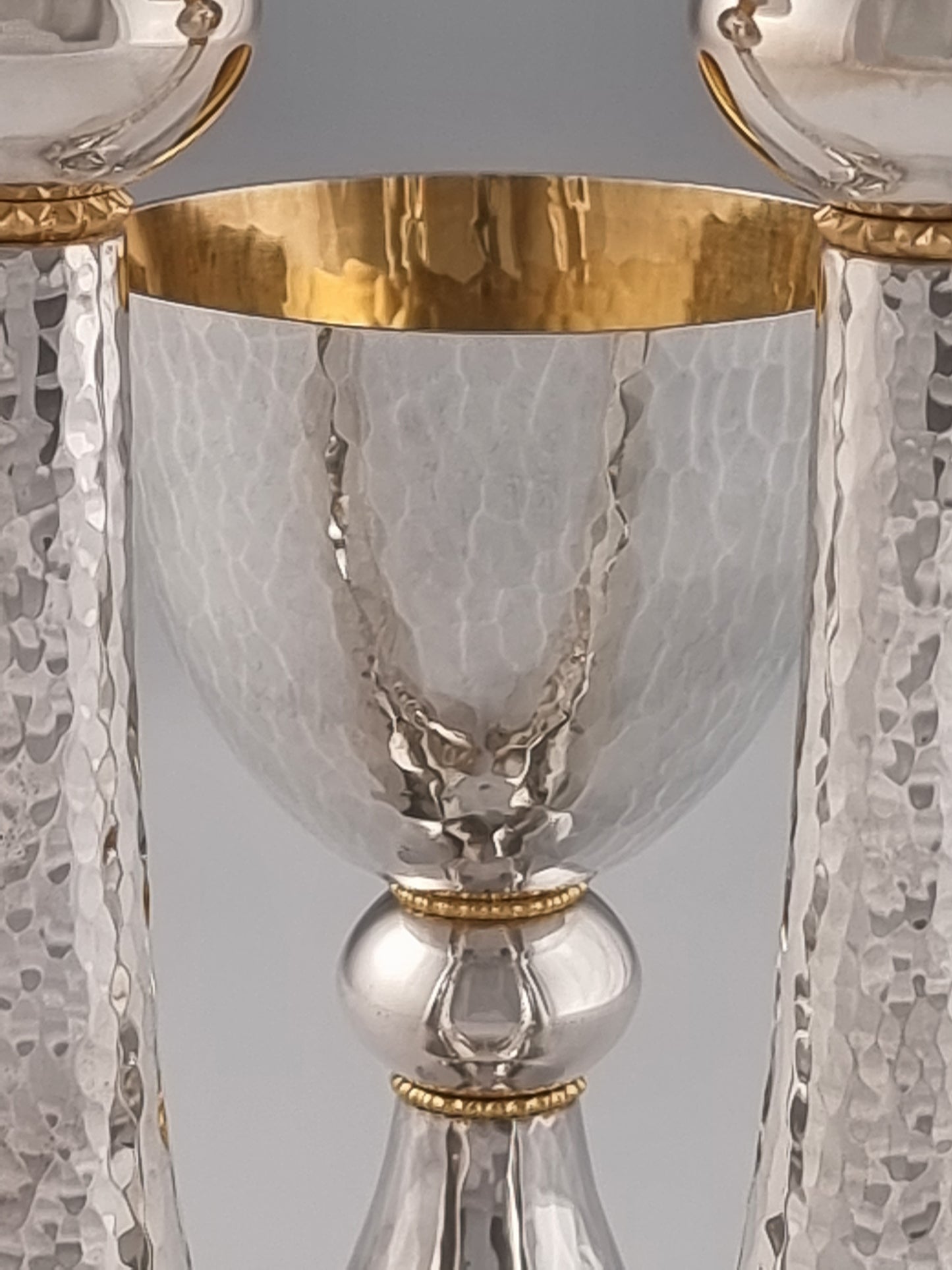 Jeremiah Kiddush Set. This set was designed in 1993. It is made of sterling silver and gold-plated silver. The cup is 5” high and the candlesticks are 7½“ high.