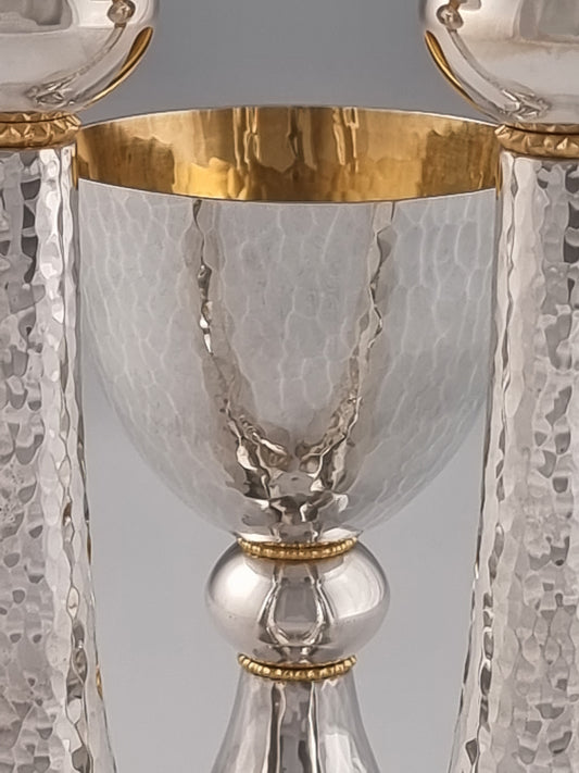 Jeremiah Kiddush Set. This set was designed in 1993. It is made of sterling silver and gold-plated silver. The cup is 5” high and the candlesticks are 7½“ high.