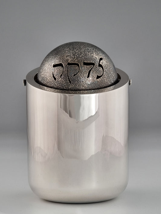 Ezekiel Tzedakah Box. This Charity Box was designed in 1992. It measures 6” high and 4” in diameter, and was created in sterling silver and oxidized sterling silver. 