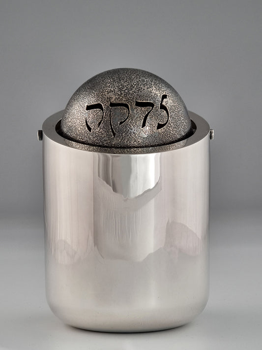 Ezekiel Tzedakah Box. This Charity Box was designed in 1992. It measures 6” high and 4” in diameter, and was created in sterling silver and oxidized sterling silver.