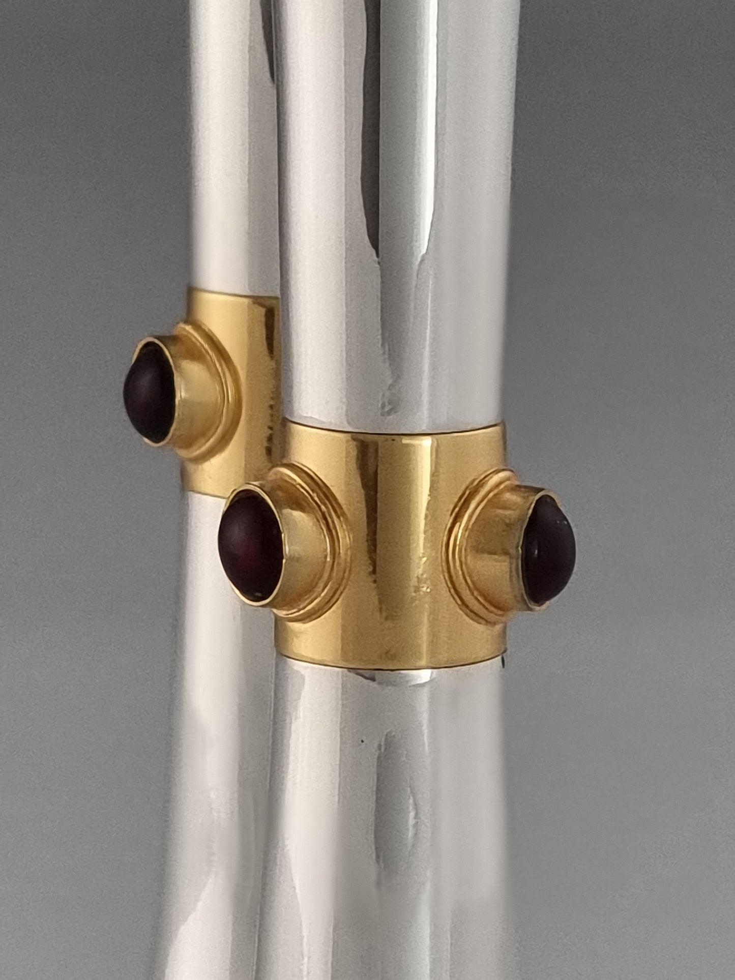 Garnet stones embedded in a gold ribbon on Deborah candlesticks
