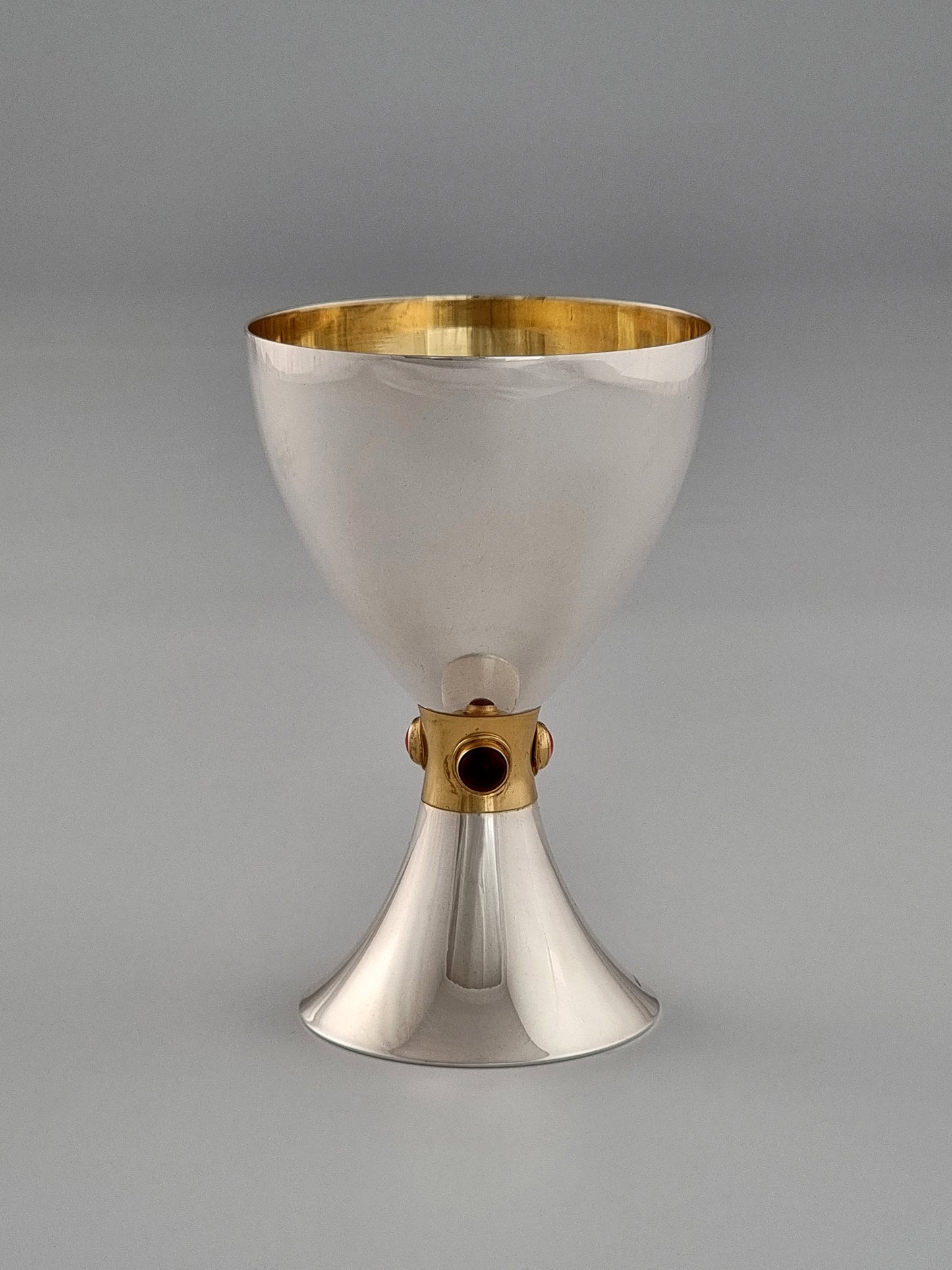 Deborah Kiddush Cup. This cup was designed in 1993. It is made of sterling silver, gold-plated silver on the inside, and adorned with three garnet stones. It measures 5" high.