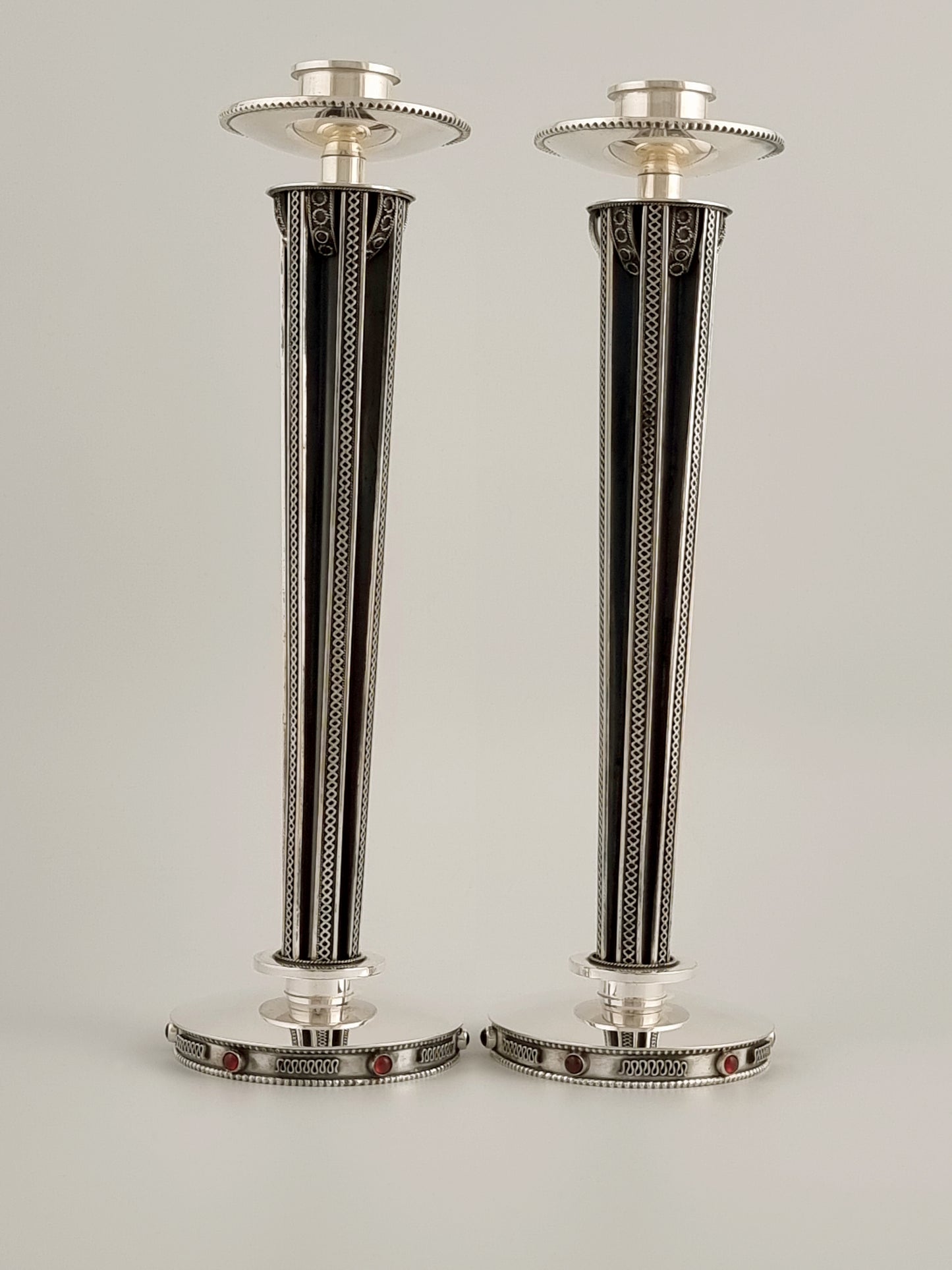 A pair of regal candlesticks made of sterling, garnet stones and oxidized silver.