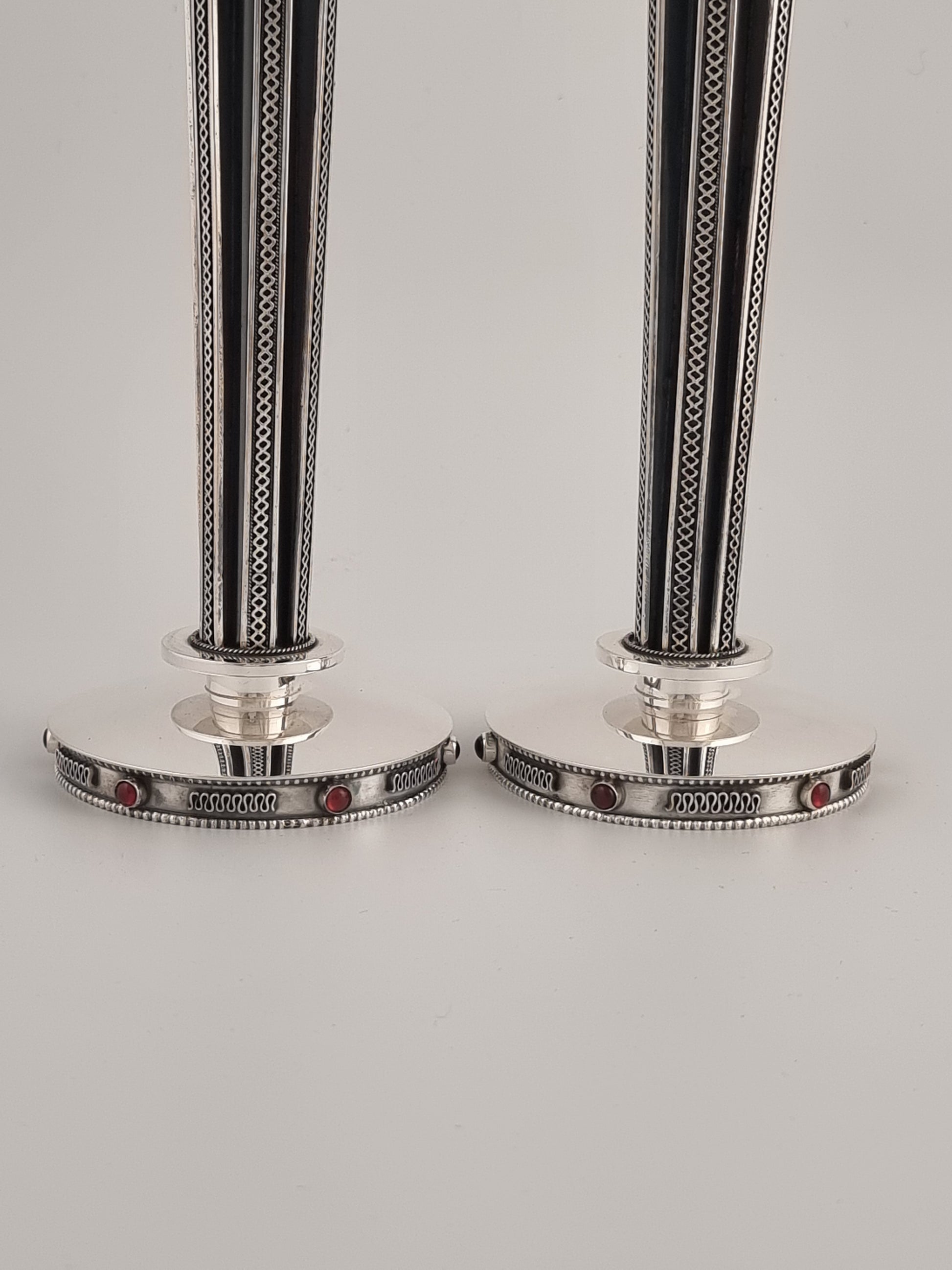 The wide smooth base supports the long pillars of these magnificent candle holders.