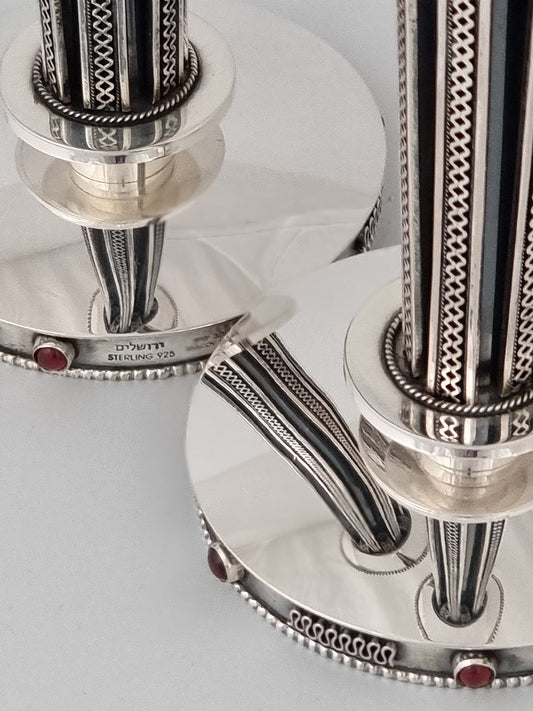 Isaac Candlesticks. These candlesticks were designed in 1952. They are 10” high and are made of silver and studded with garnet stones.