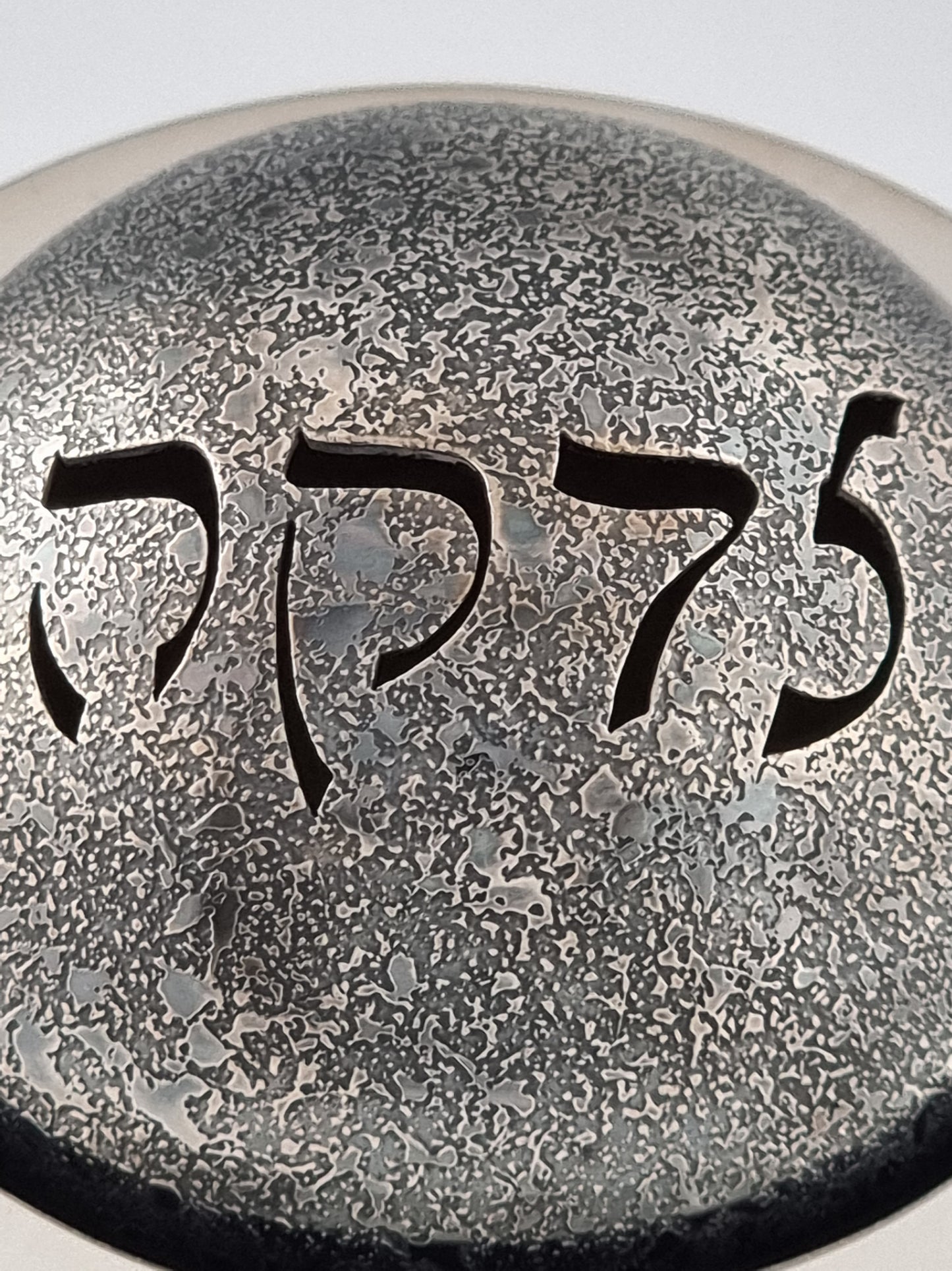 A close-up on the word "Tzedakah". 